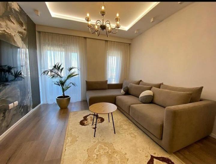 uma sala de estar com um sofá e uma mesa em Korce Edea's 2 ApartHotel em Korçë