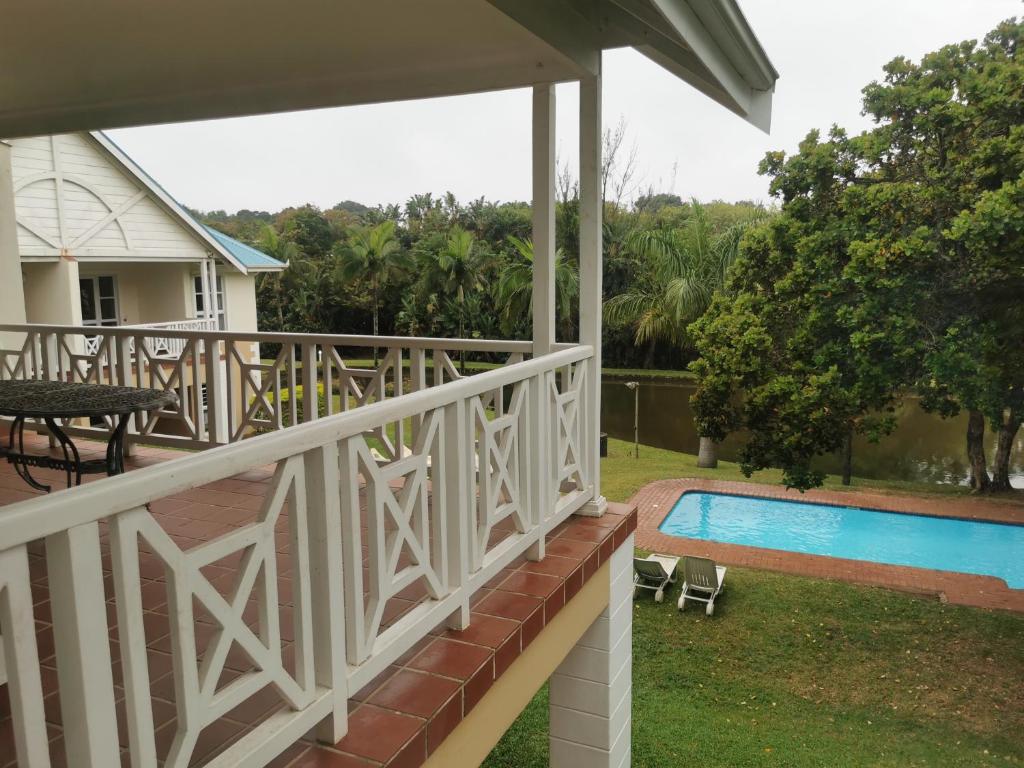 a balcony of a house with a swimming pool at Tortuga 22 - Caribbean Estates in Port Edward