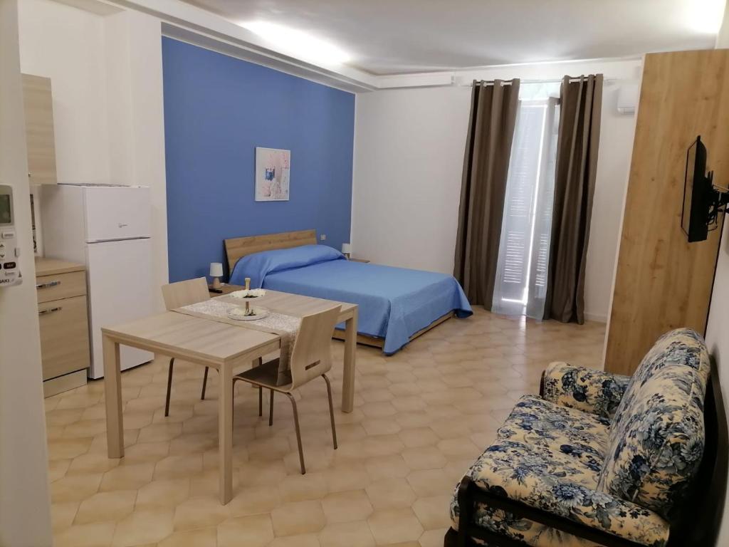 ein Schlafzimmer mit einem Bett, einem Tisch und einem Sofa in der Unterkunft Casa dell’Assunta in Trani