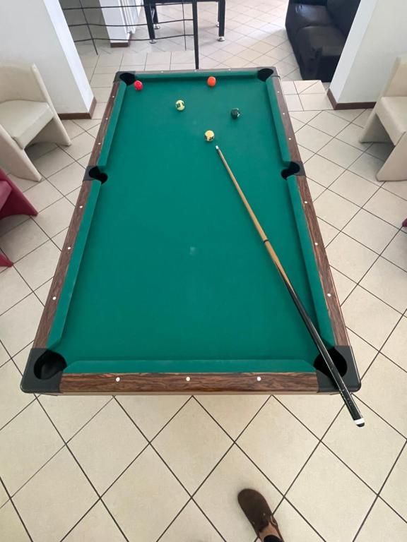 a pool table with two balls and two cue sticks at Lunga Via Delle Dolomiti in Calalzo