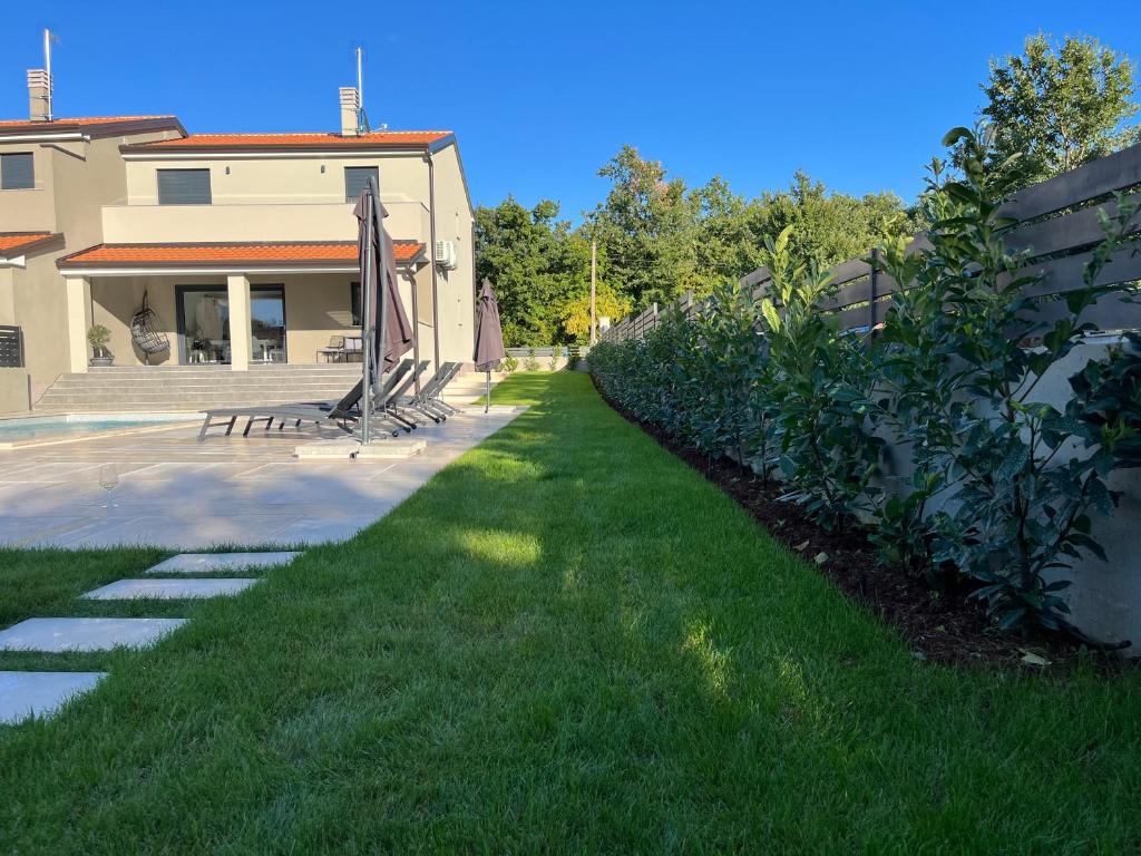einen Hof mit grünem Gras neben einem Haus in der Unterkunft Casa Mia in Poreč