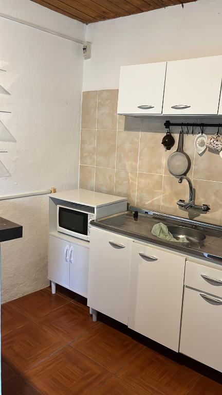 uma cozinha com armários brancos e um lavatório em Apto AMARILLO em Rocha
