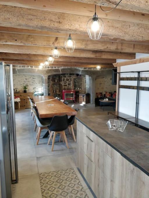 une cuisine avec une table en bois et une salle à manger dans l'établissement Location maison Bourboule, à Murat-le-Quaire