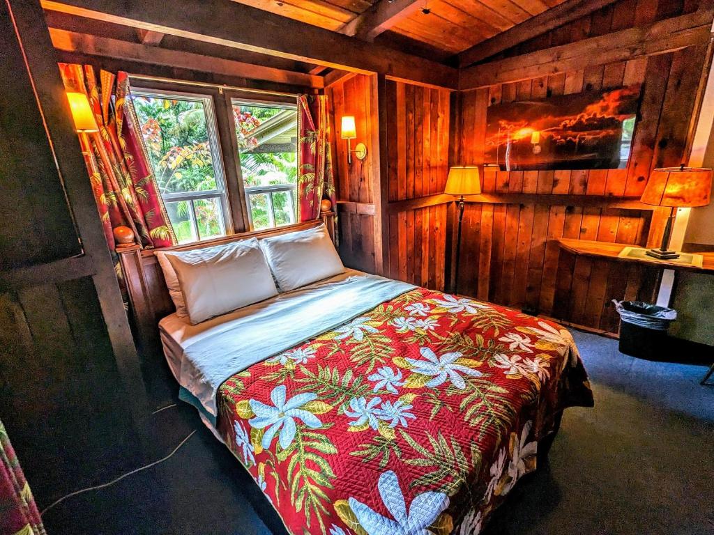 Pahoa的住宿－Kehena Mauka Nui Club LGBTQIA+ Clothing Optional，木制客房内的一间卧室,配有一张床