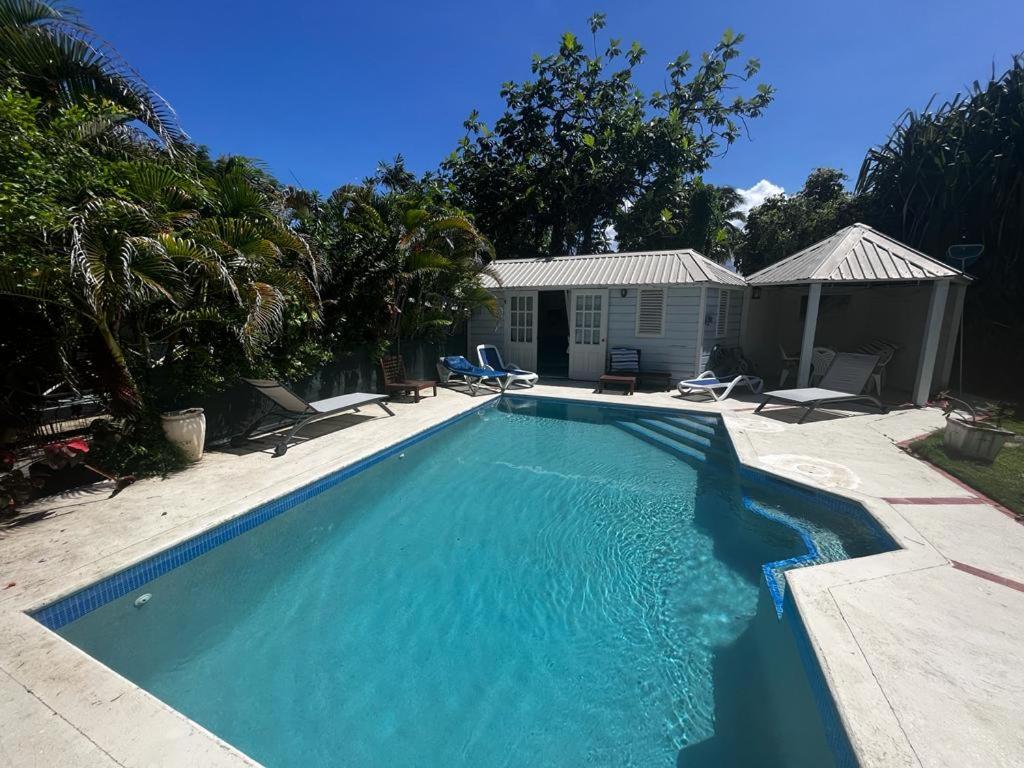 a swimming pool in front of a house at Rafeen villa- Historic villa with pool in Bridgetown