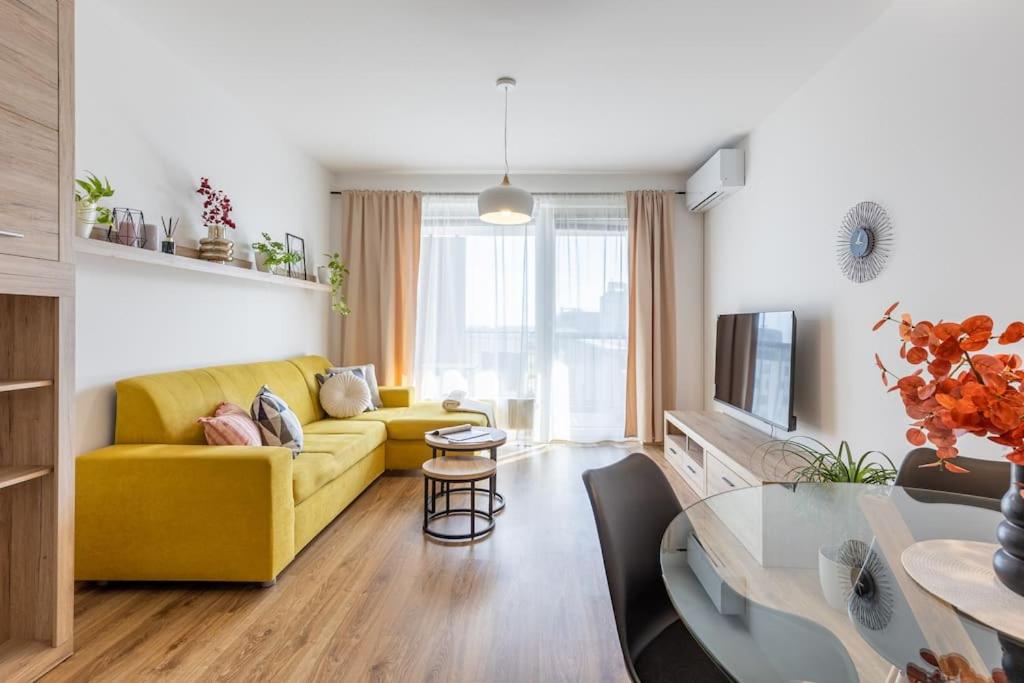a living room with a yellow couch and a table at BNB Slovakia Slnečnice Apartment 1 in Bratislava