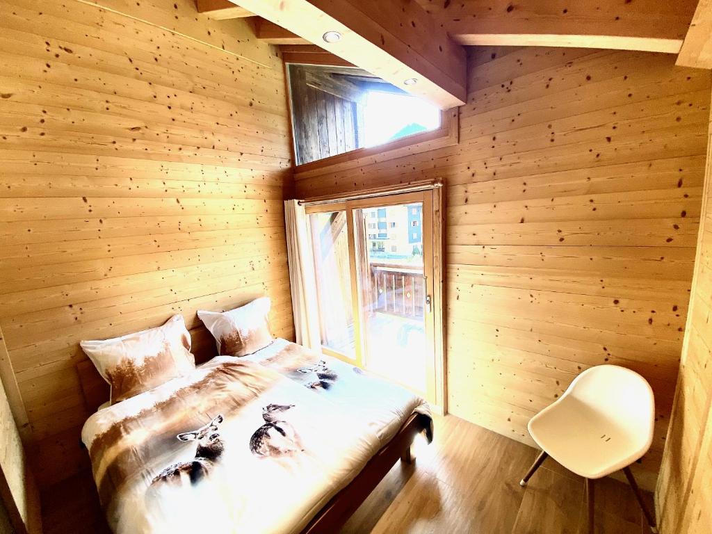 - une chambre avec un lit dans une pièce en bois dans l'établissement Chalet Neuf, Morgins, à Morgins
