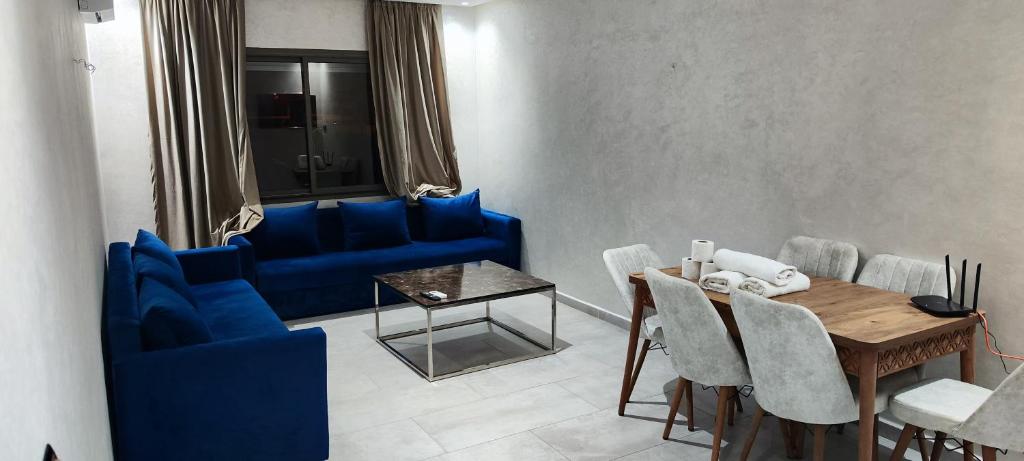 a dining room with blue chairs and a table at Les Belles Appartements Family Only in Tangier