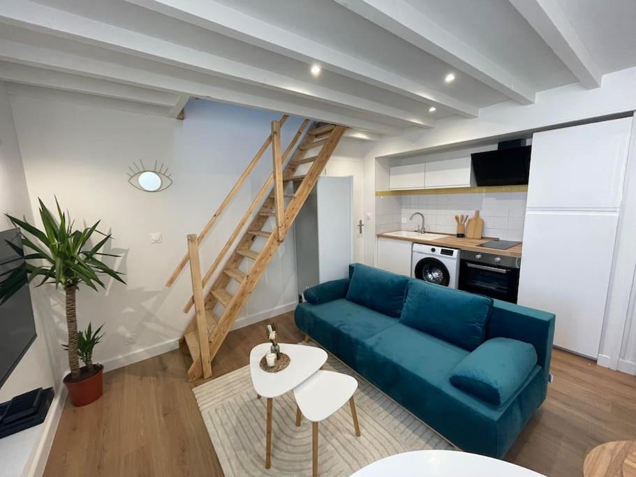 sala de estar con sofá azul y escalera en Le Cordelier-Proche marché central et vieux port-wifi haut débit-, en La Rochelle