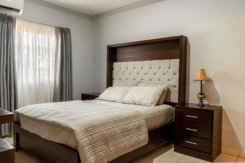 a bedroom with a large bed with a wooden headboard at Residencial Del Golf in La Lima