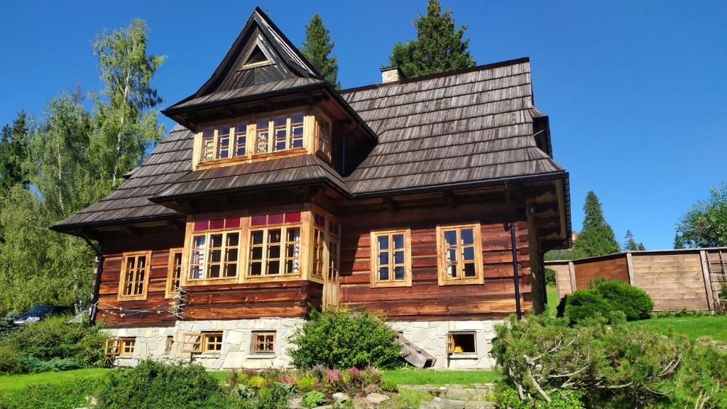 a large wooden house with a black roof at Dom na Pawlikach in Rzepiska