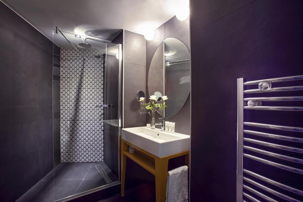 a bathroom with a sink and a mirror at Grand Hôtel du Midi Montpellier - Opéra Comédie in Montpellier