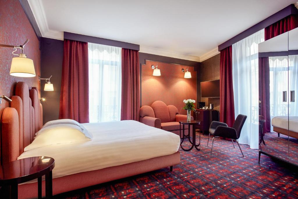 a hotel room with a bed and a salon at Grand Hôtel du Midi Montpellier - Opéra Comédie in Montpellier