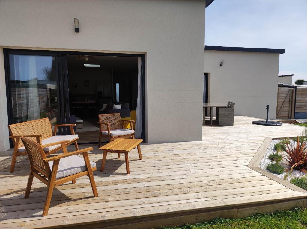 een houten terras met stoelen en tafels op een huis bij Le Petit Cocon Portsallais Mer à 200m PORTSALL in Ploudalmézeau