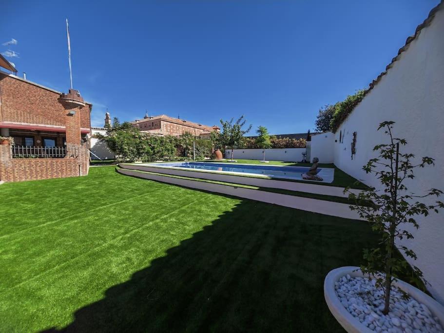 a yard with a swimming pool and green grass at Teralba 1 Casa Rural in La Calzada de Oropesa