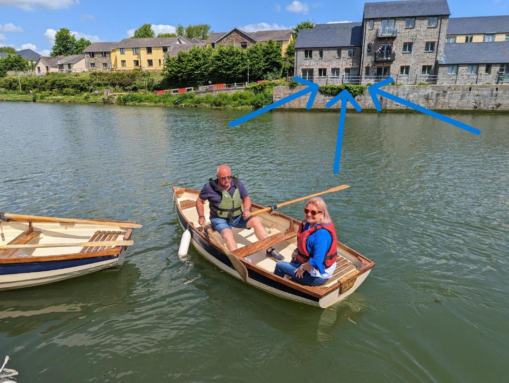 two people sitting in a row boat in the water at Castle Pond House in Pembroke