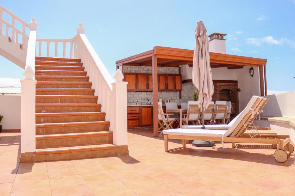 eine Terrasse mit einer Treppe, einem Stuhl und einem Haus in der Unterkunft Maruca (D): En familia. in Breña Baja