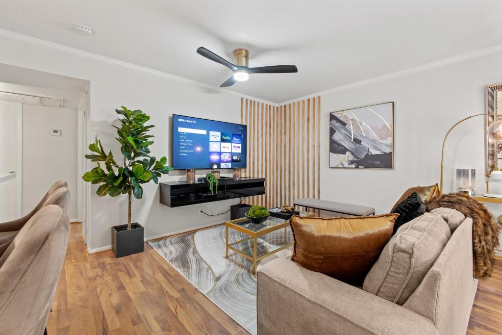 a living room with a couch and a flat screen tv at Luxe and Modern Dallas Condo 2 Mi to Highland Park! in Dallas