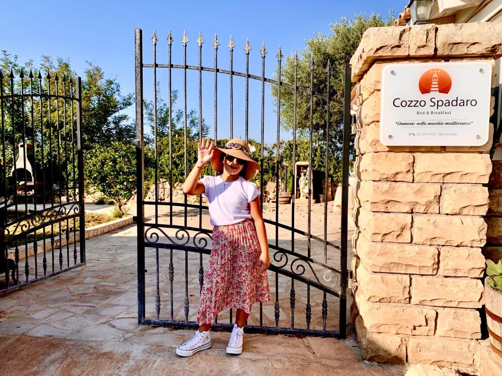 uma jovem em pé em frente a um portão em Cozzo Spadaro B&B em Portopalo