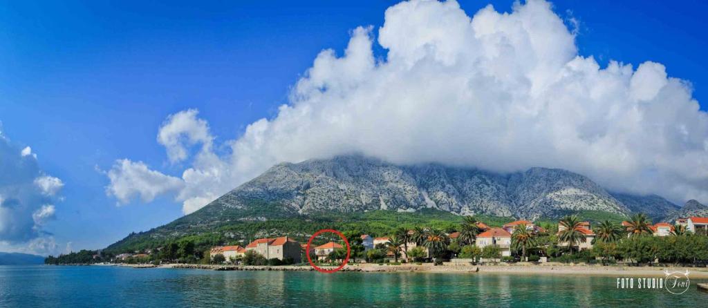 una montagna in lontananza con case su una spiaggia di Apartments Lenka a Orebić (Sabbioncello)