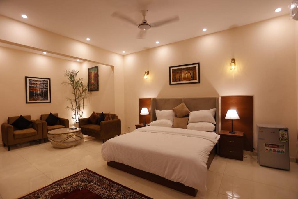 The Elet Signature Boutique Hotel في كراتشي: غرفة نوم مع سرير وغرفة معيشة