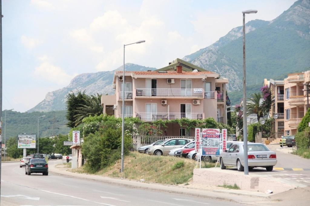 a street with cars parked in front of a building at Apartments Petricevic in Sutomore