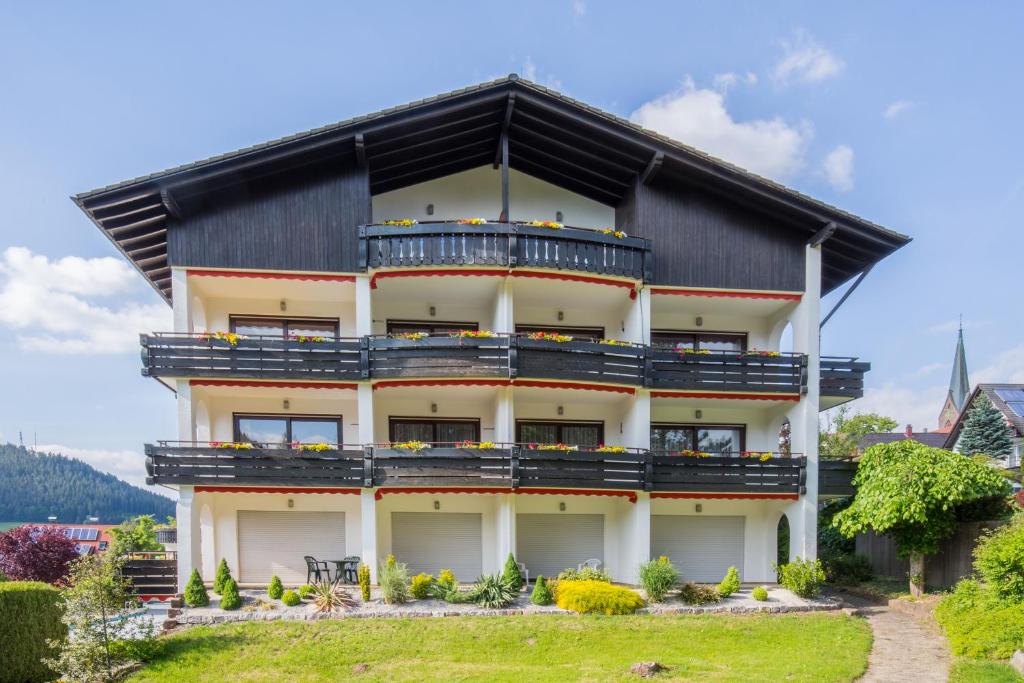 a house with a black roof and balconies at BSW Schwarzwaldhotel Baiersbronn in Baiersbronn