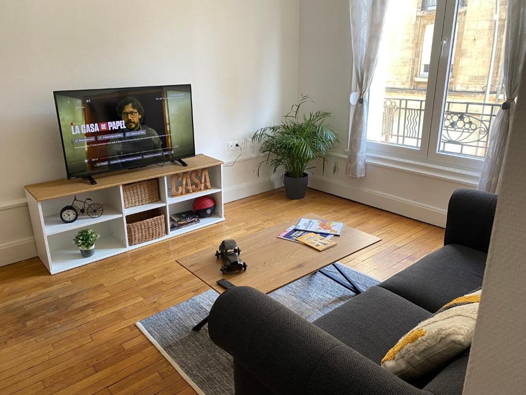 a living room with a couch and a television at Appart hyper-centre, à 5 min à pieds de la gare in Longwy