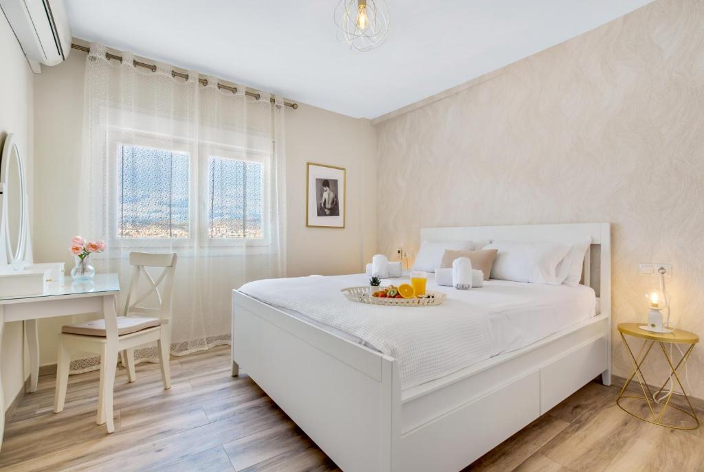 una camera bianca con un letto e un vassoio di frutta di Nuestro Rincón de Málaga a Málaga