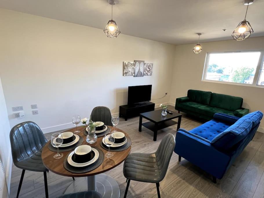 uma sala de estar com uma mesa e um sofá em Spacious One Bedroom Apartment em Hemel Hempstead
