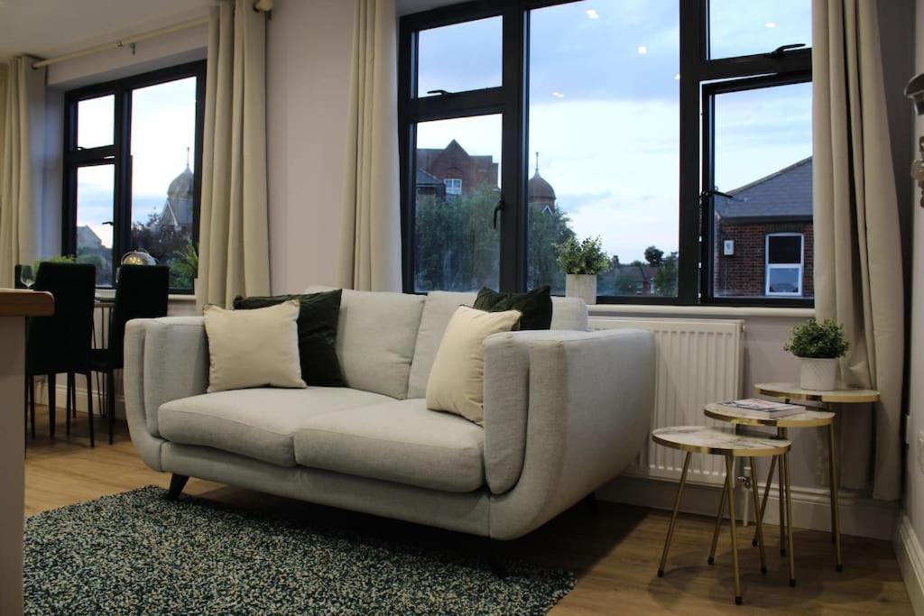 a white couch in a living room with windows at Lavish London Stay Near Wembley Stadium in London