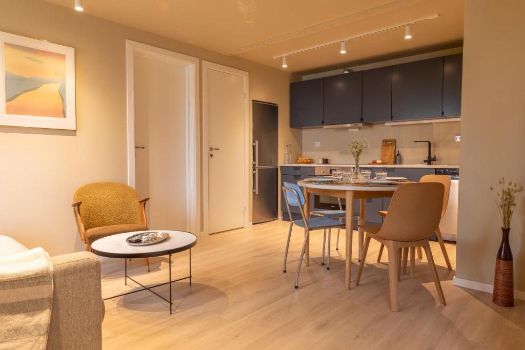 een keuken en een woonkamer met een tafel en stoelen bij Elegant apartment in city centre in Tromsø