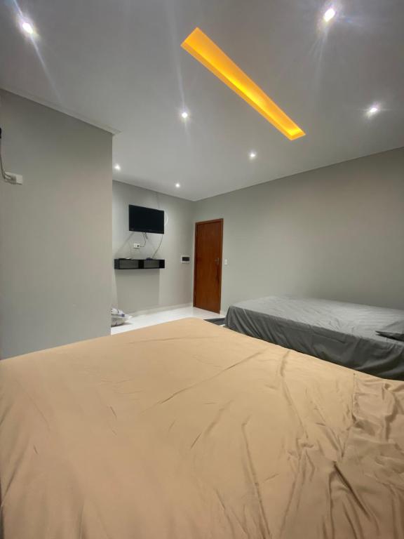 1 dormitorio con 1 cama grande y TV en Apartamento Espanha, en Ciudad del Este