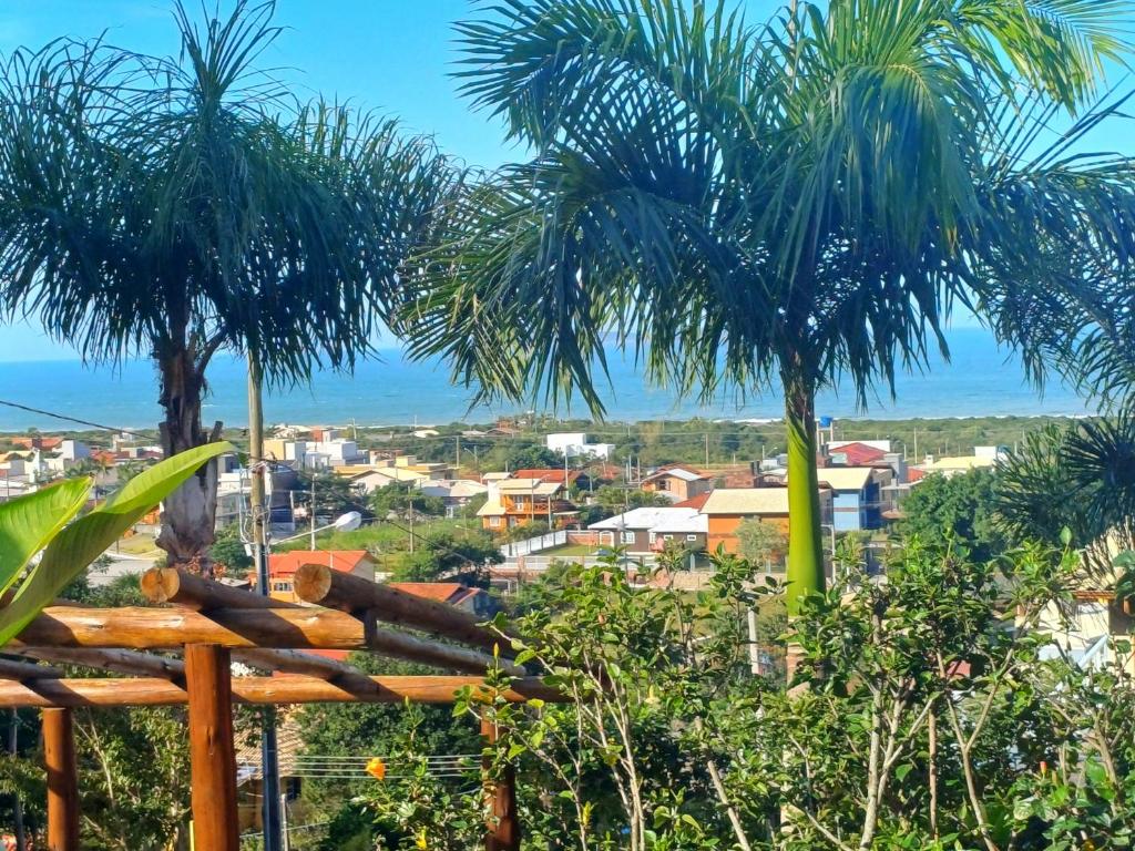 a view of a city with two palm trees at Residencial Hibiscos - Vista Mar in Garopaba