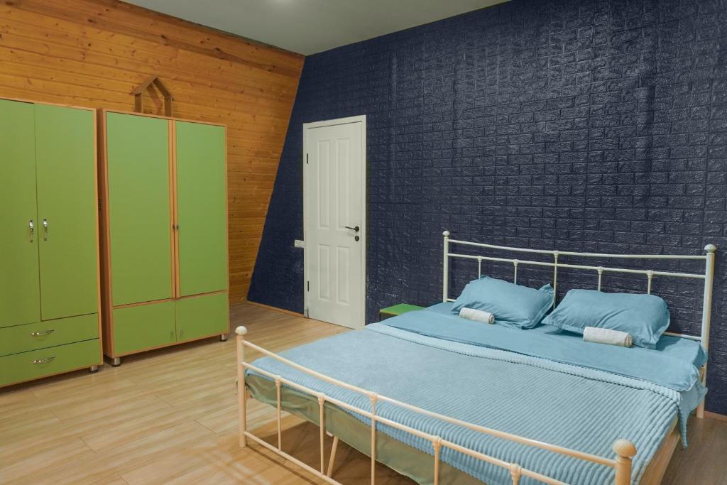 een slaapkamer met een bed en een bakstenen muur bij Alagi Cottage at Bazaleti lake in Grigolaantkari