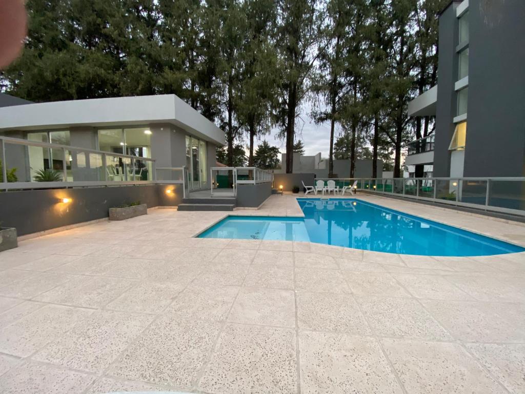a swimming pool in front of a building at Departamento impecable ,complejo cerrado, asador y pileta in Villa Allende