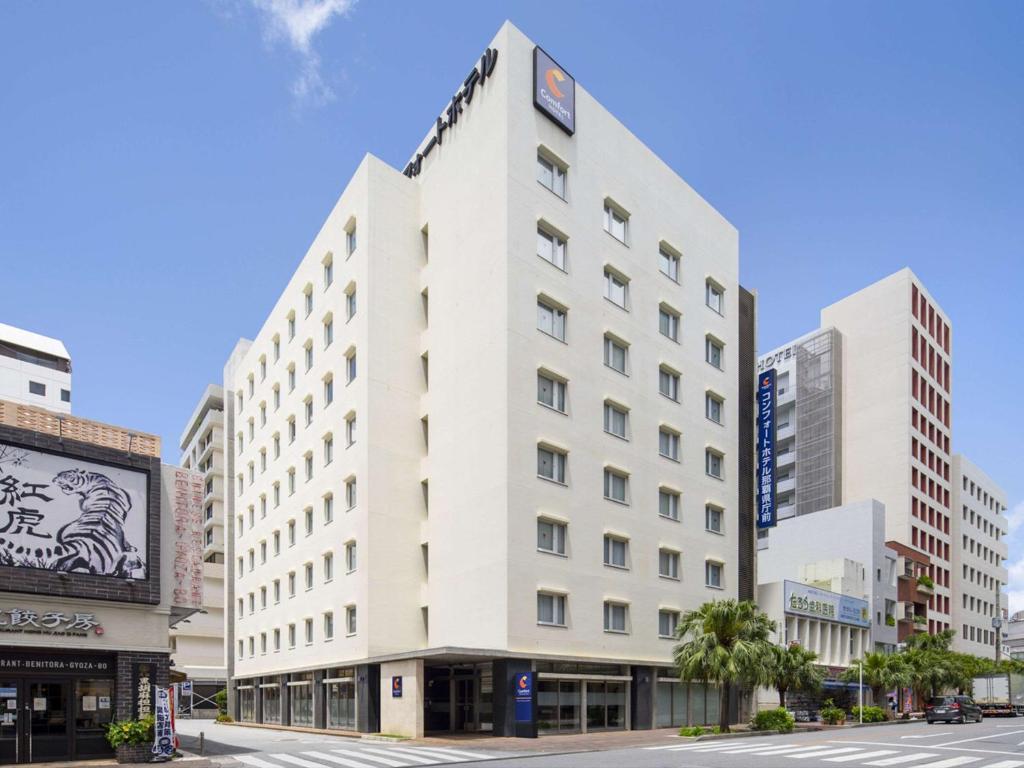 Un bâtiment blanc avec une horloge en haut dans l'établissement Comfort Hotel Naha Prefectural Office, à Naha