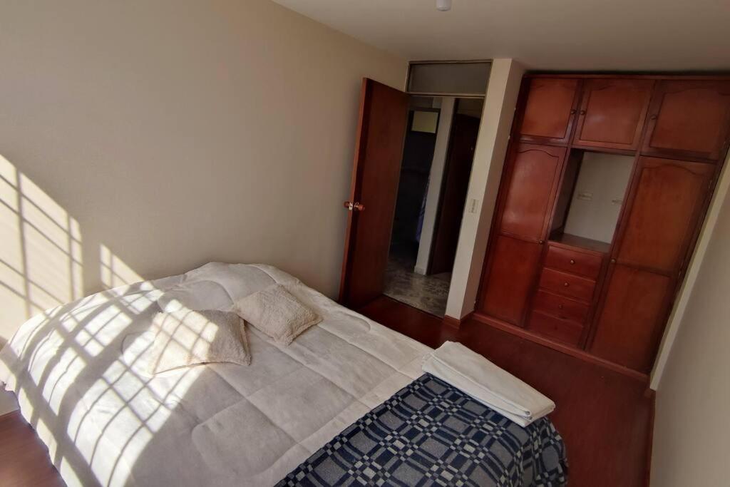 a bedroom with a bed and a wooden cabinet at Acogedor y Luminoso apartamento in Tunja