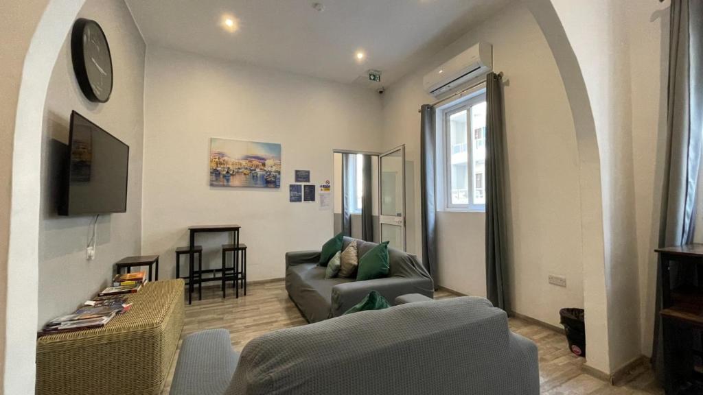 salon z kanapą i stołem w obiekcie Bookarest Hostel Malta w mieście St. Julian’s
