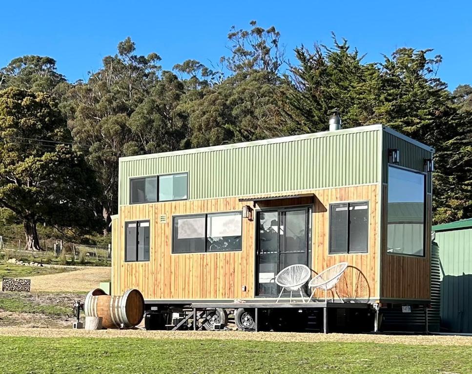 a tiny house sitting on top of a field at Little Pardalote Tiny Home Bruny Island in Alonnah