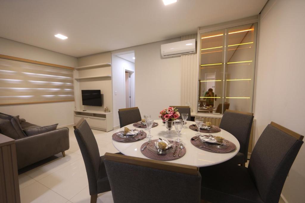 ein Esszimmer mit einem Tisch und Stühlen sowie ein Wohnzimmer in der Unterkunft Apartamento Espaço Aconchegante in Foz do Iguaçu