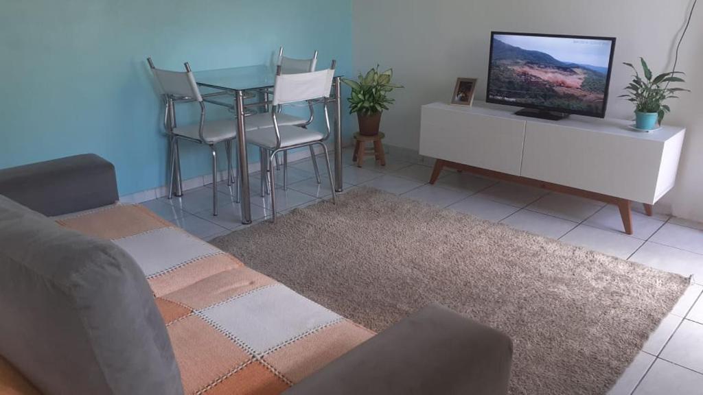 a living room with a table and a tv at Lar sossego in Itabuna