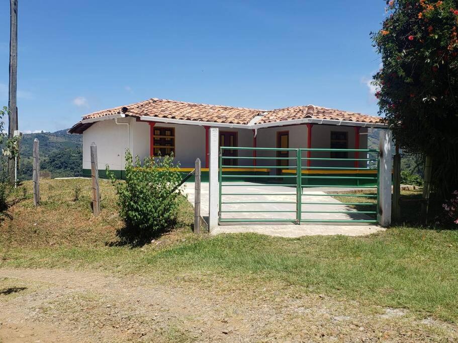 ein kleines Haus mit einem Tor davor in der Unterkunft Casa de Campo el mirador in Jericó