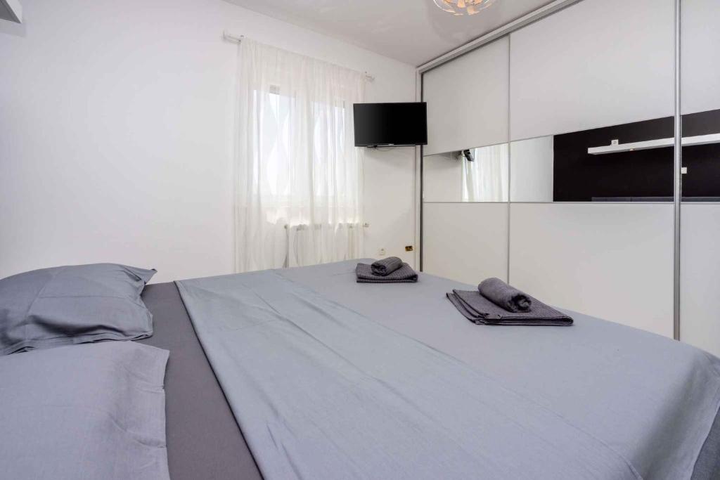 ein Schlafzimmer mit einem Bett mit zwei Hausschuhen darauf in der Unterkunft Apartments in Dramalj 45020 in Dramalj