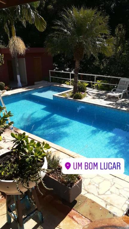 a blue swimming pool with a chair and some plants at Casa de Campo Terra da Paz in Itatiba