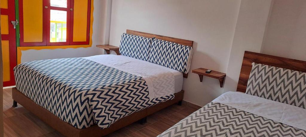 1 Schlafzimmer mit 2 Betten und einem Fenster in der Unterkunft HOTEL CAFETERO in Líbano