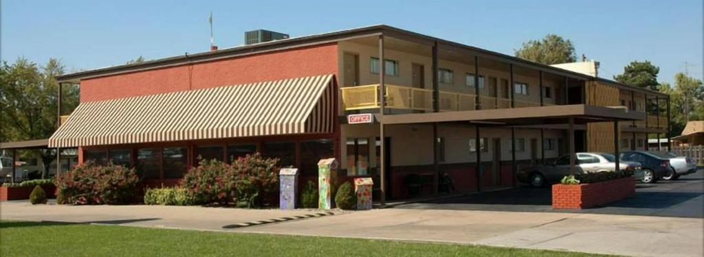 a red brick building with cars parked in front of it at Big Bend Traveler's Inn in Great Bend