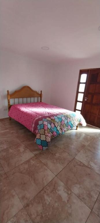 a bedroom with a bed with a pink comforter at faroleee in Rodeo de la Cruz