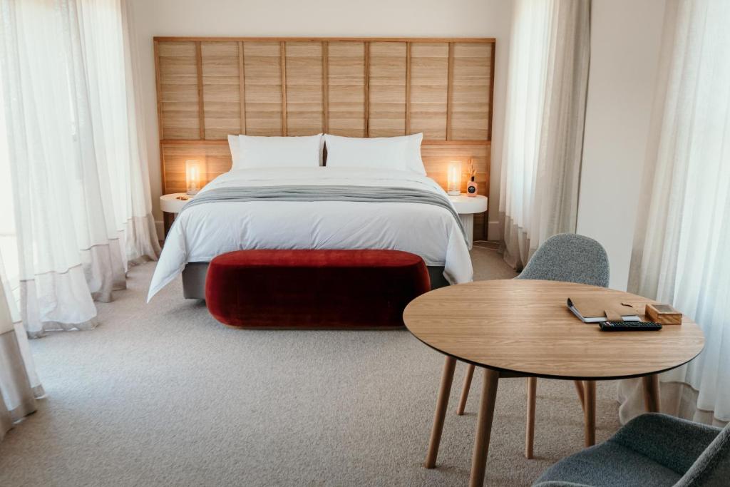 um quarto com uma cama, uma mesa e cadeiras em The Oak & Anchor Hotel em Port Fairy