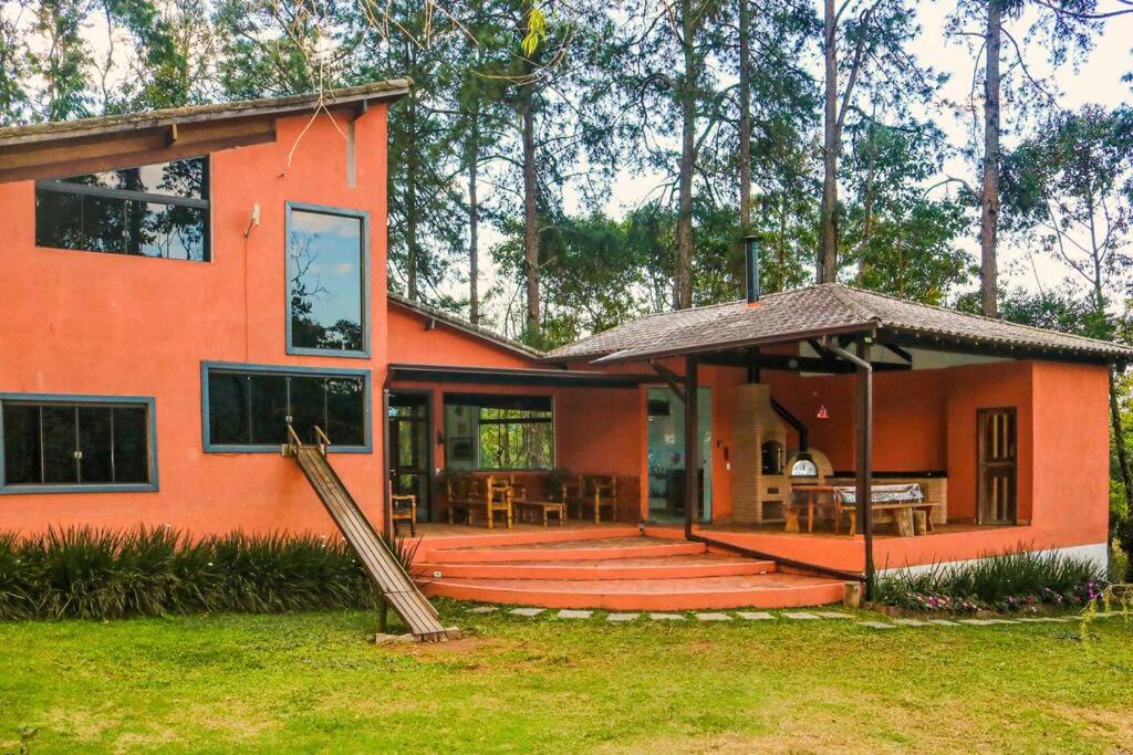 a orange house with a porch and a patio at Refúgio na Serrinha do Alambari - Penedo -RJ in Resende